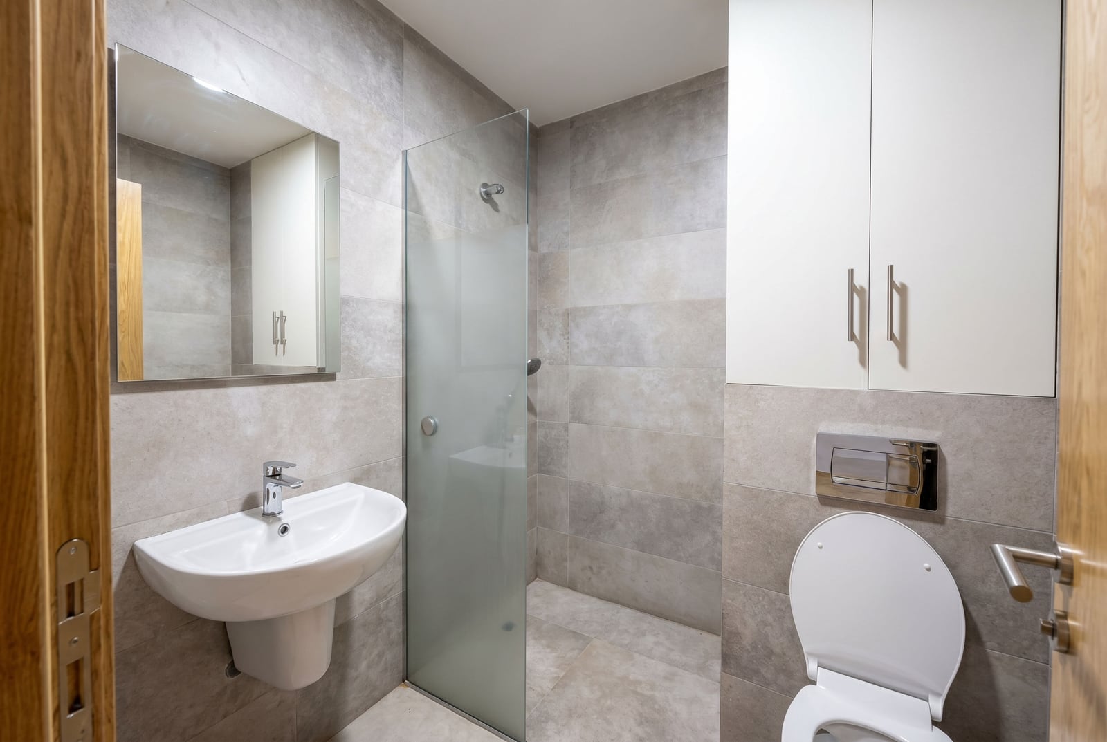 Modern bathroom with a walk-in shower in an apartment in Bečići, Montenegro: tiles, sanitary ware, and furniture.