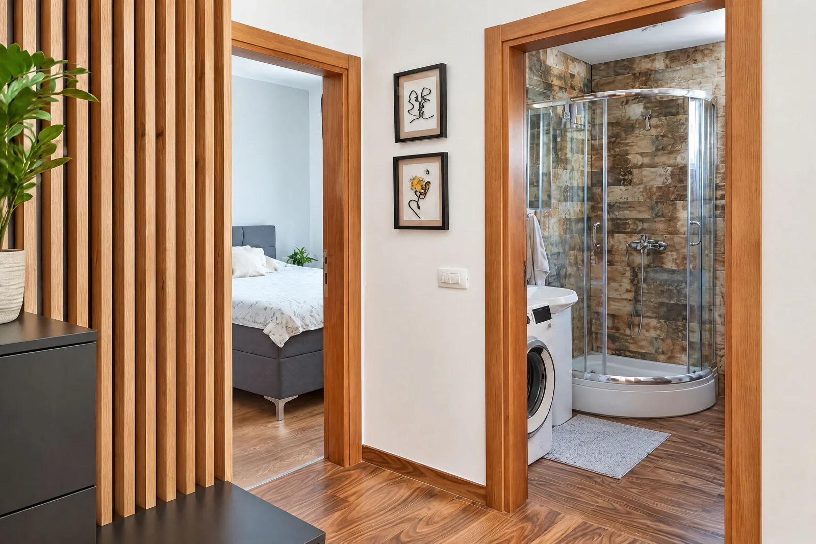 Hallway showing a bedroom through one door and a bathroom with a shower and washing machine through another.