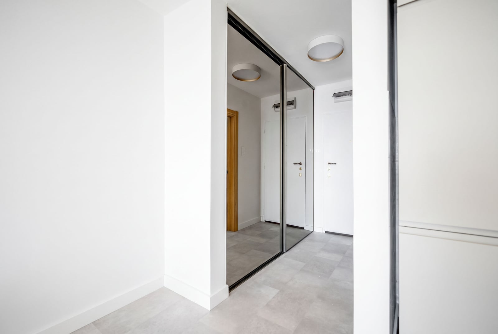 Bright hallway with a mirrored wardrobe and modern finishes in an apartment, Sveti Stefan, Montenegro.