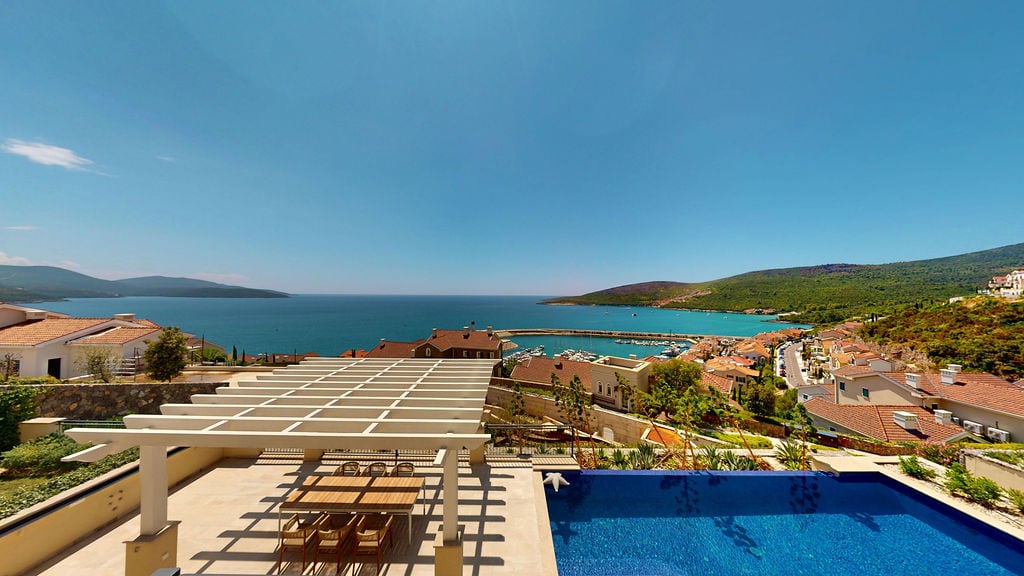 Sea and marina view from the terrace of a villa with a pool in Luštica, Montenegro: pergola, dining area, and panoramic landscape.