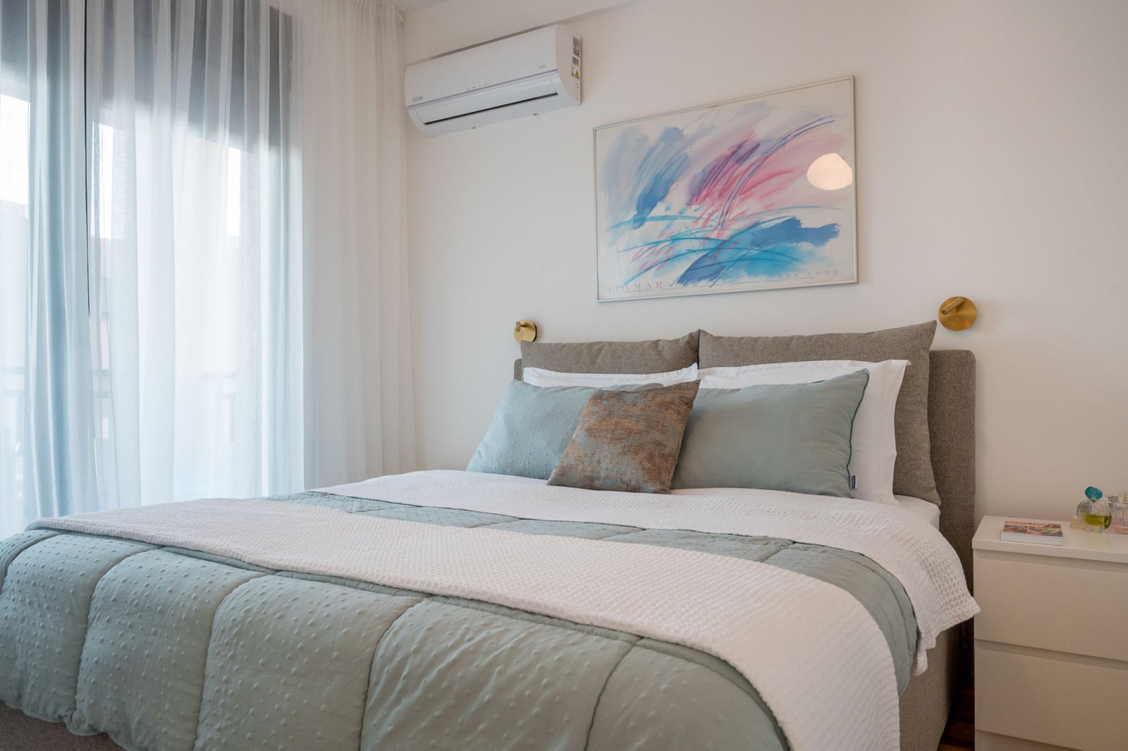 Cozy bedroom with a double bed in an apartment in Tivat, Montenegro: modern interior, air conditioning, and decor.