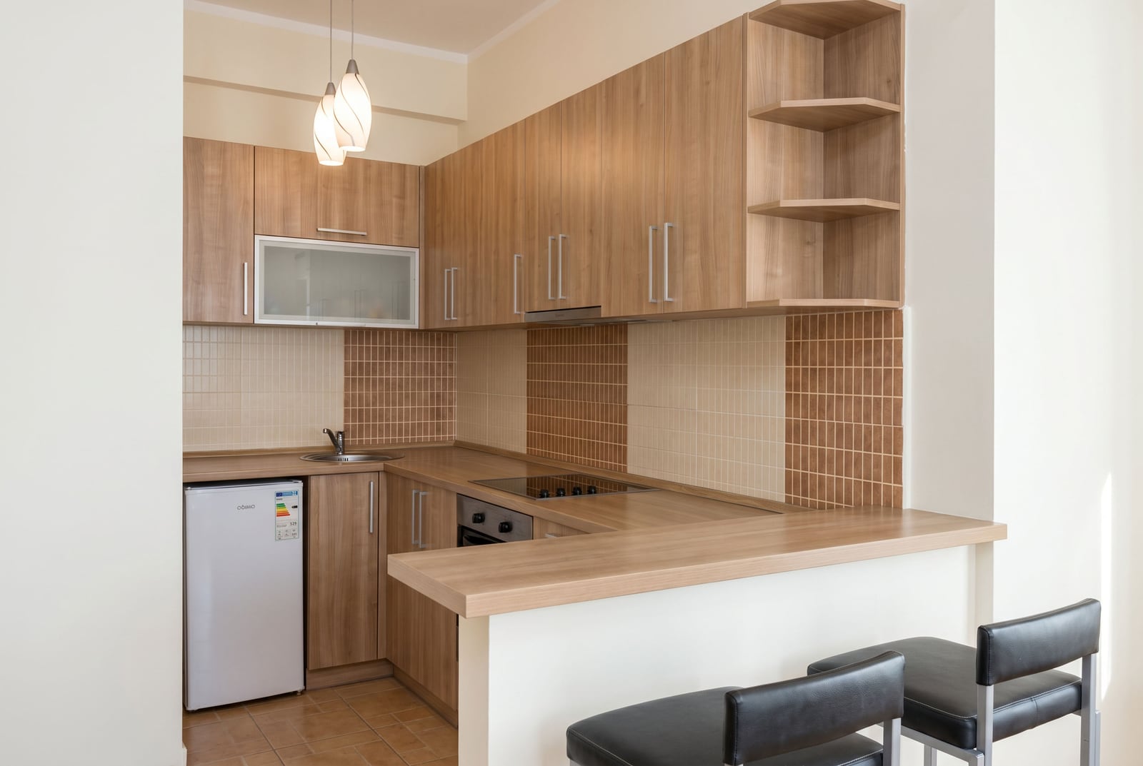Modern kitchen with wooden cabinets and a breakfast bar in an apartment, Budva, Montenegro.