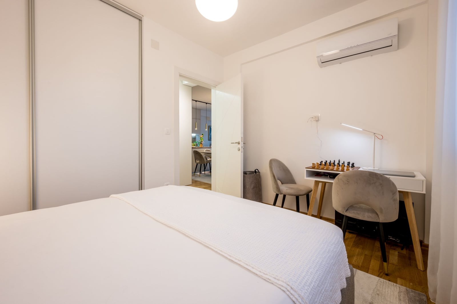 Bright bedroom with a workspace and a bed in a modern apartment, Tivat, Montenegro.
