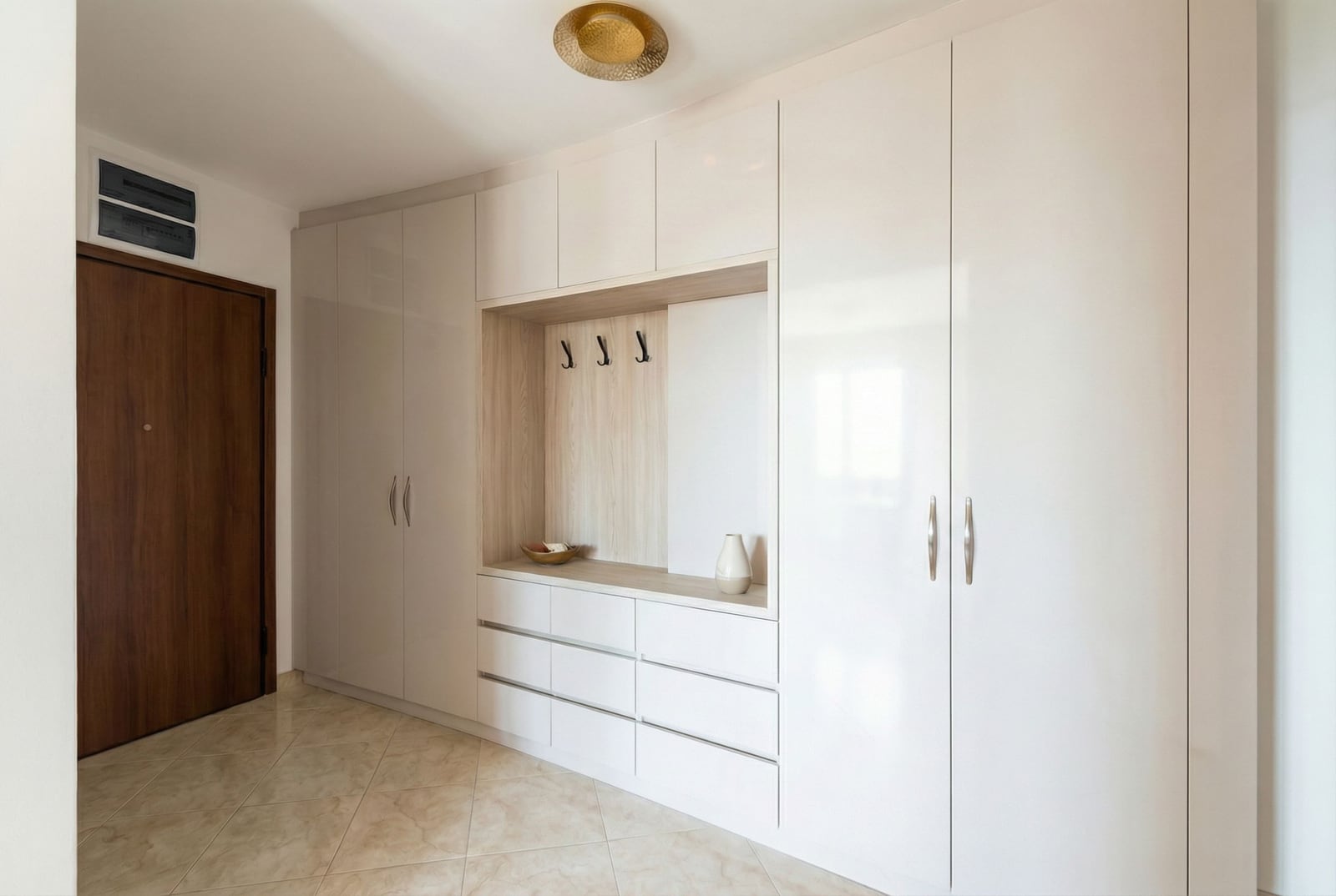 Modern hallway with a built-in white wardrobe and a niche in an apartment in Becici, Montenegro.