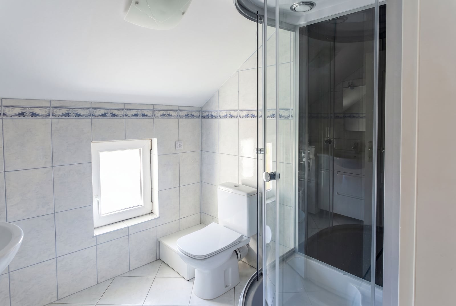 Bright bathroom in a house in Krašići, Montenegro: shower cabin, sanitary ware, and a skylight window.