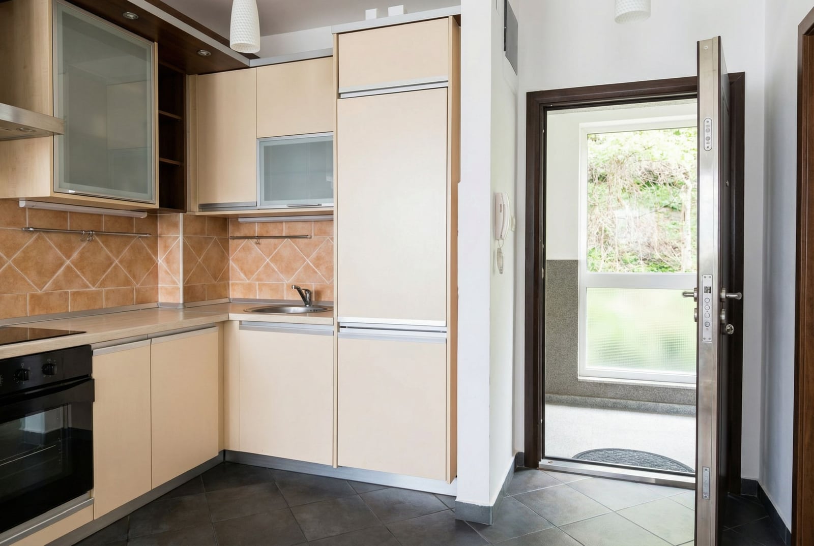 Modern kitchen in an apartment in Petrovac, Montenegro: light cabinetry, built-in appliances, and access to the terrace.