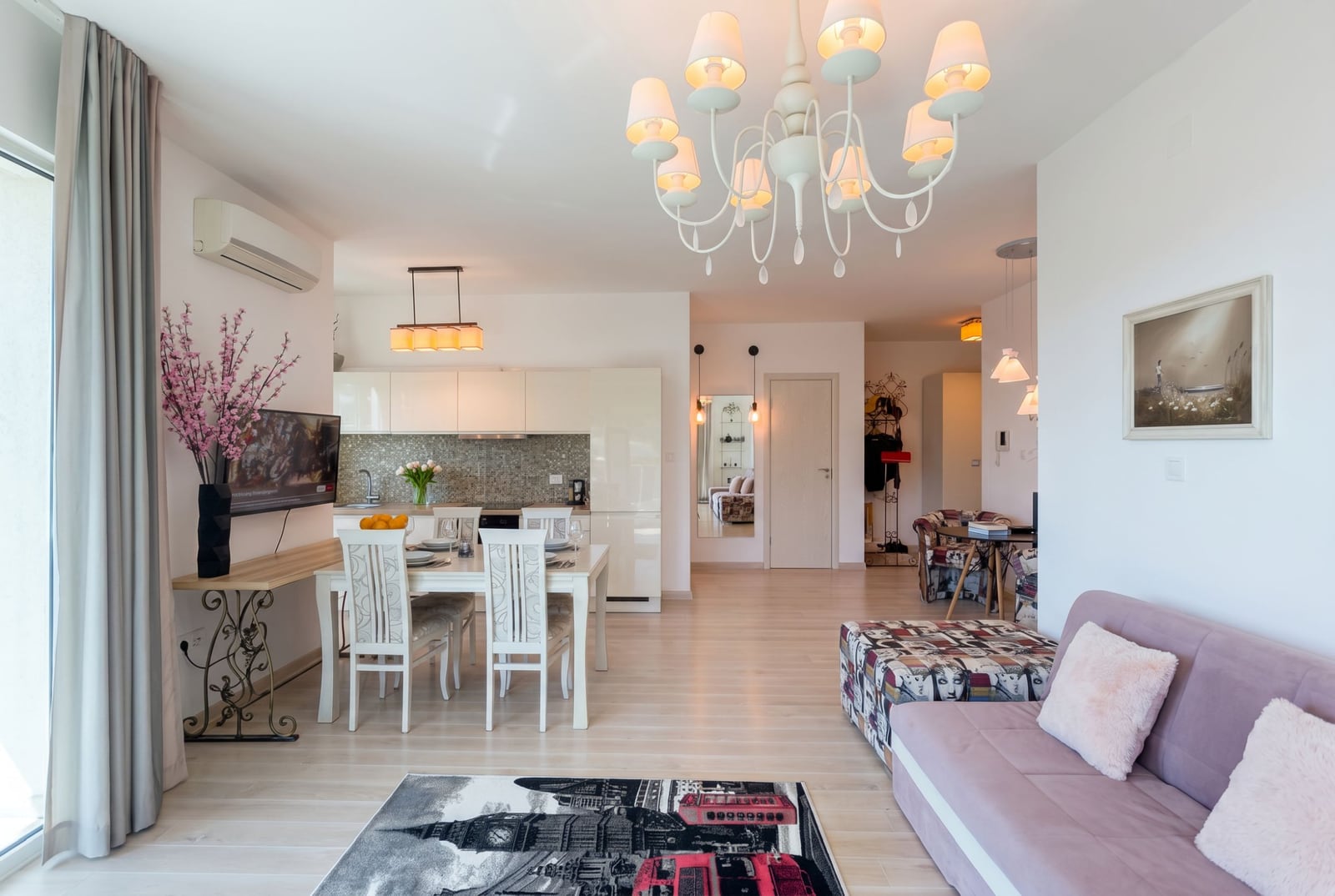 Modern living room with kitchen in an apartment in Bečići, Montenegro: bright interior, dining area, and a comfortable sofa.
