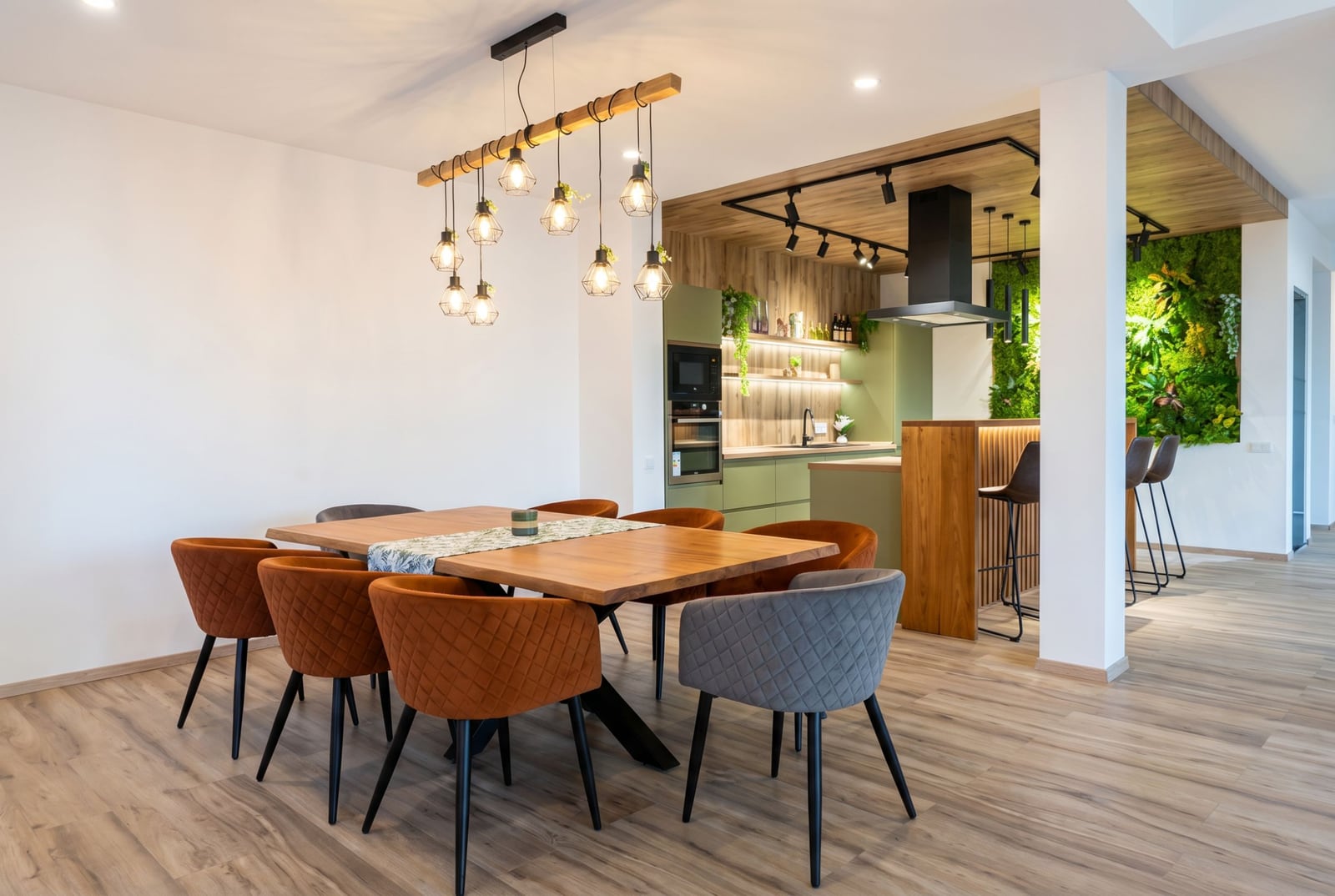 Modern kitchen-dining room in a villa in Kavac, Montenegro: dining table, designer chairs, and a living plant wall.