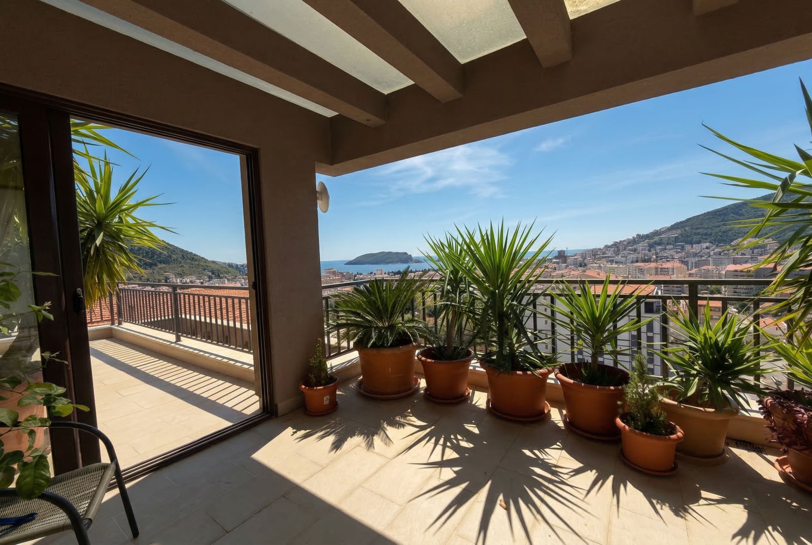 Spacious terrace with sea and Budva views, Montenegro: panoramic balcony with plants and an awning in apartment No. 2588.