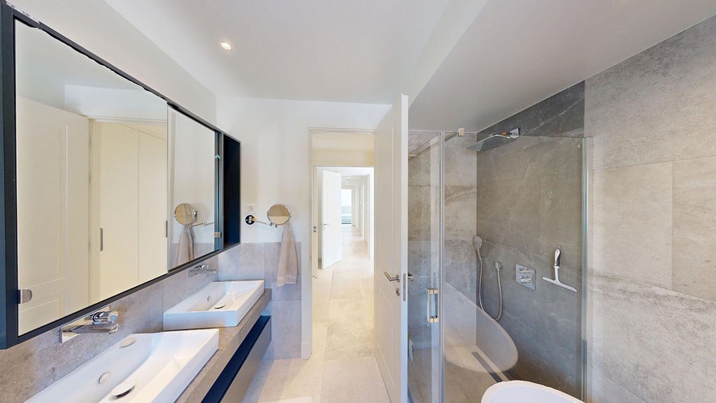 Modern bathroom with a shower cabin and double sink in a villa in Luštica, Montenegro.
