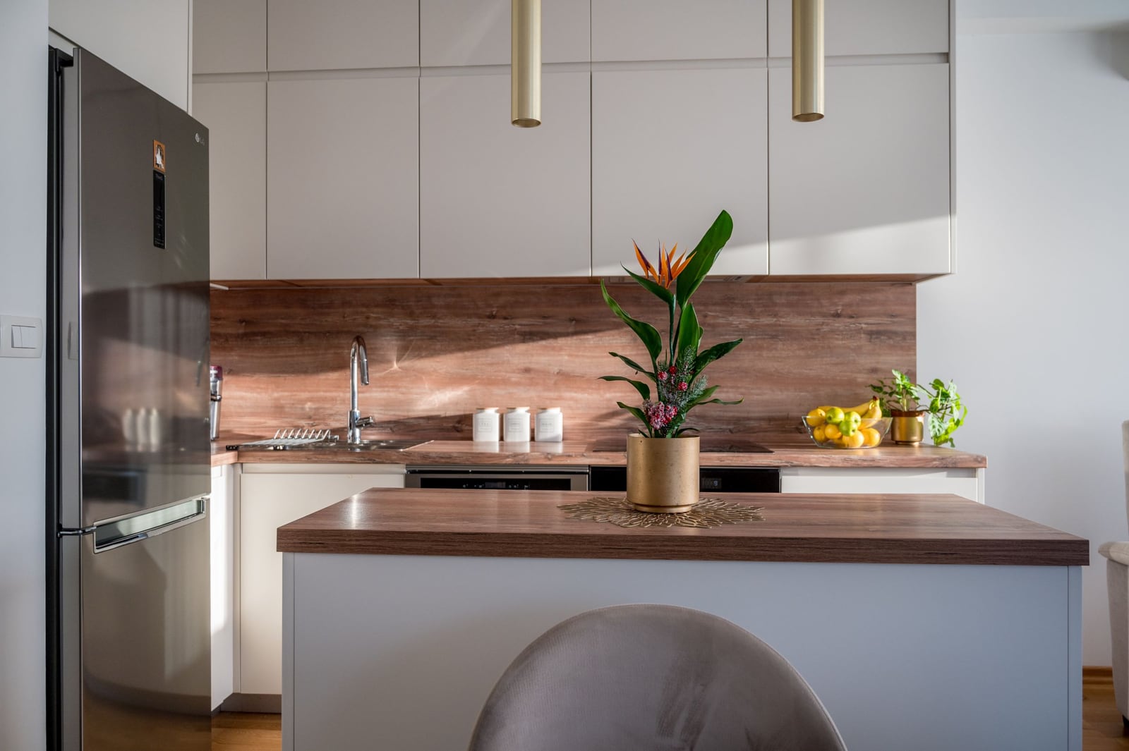 Modern kitchen in a Tivat apartment, Montenegro: light-colored cabinetry, wooden countertop, and kitchen island.