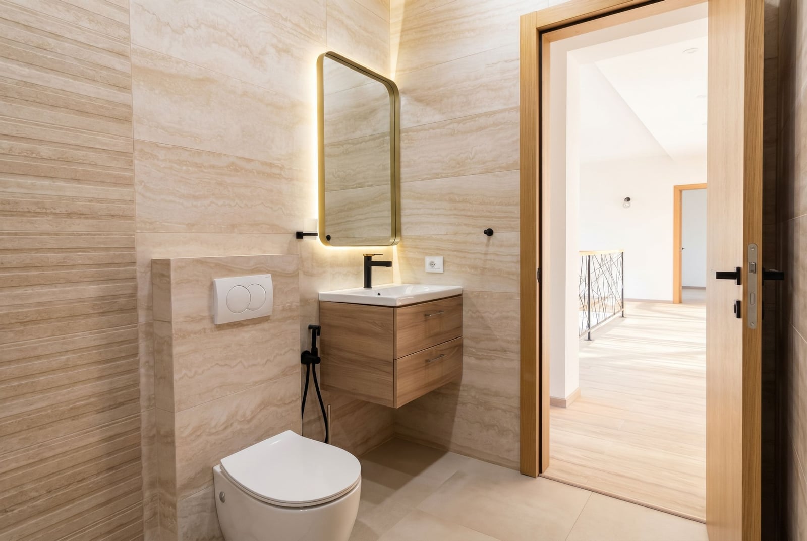 Modern bathroom with travertine-style finishes in a villa in Kavac, Montenegro: wall-mounted vanity and backlit mirror.