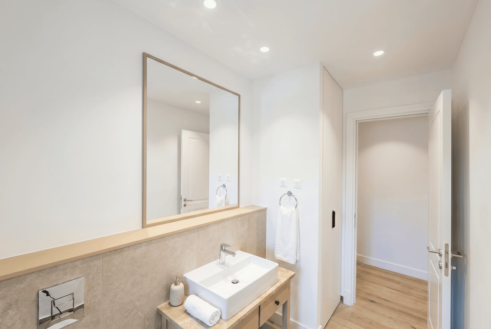 Modern bathroom in an apartment in Luštica, Montenegro: white sanitary ware, mirror, and light-toned finishes.