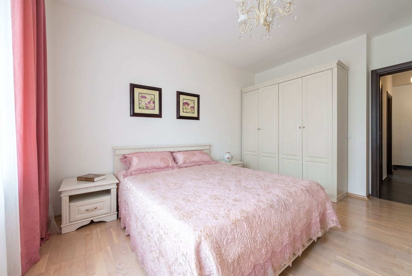 Bright bedroom with a double bed and a wardrobe in an apartment, Kumbor, Montenegro. Classic interior with pink decor.