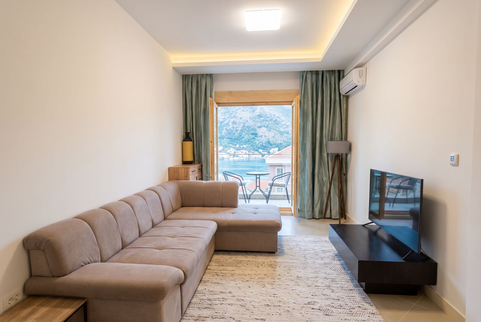 Living room with a corner sofa and a view of the Bay of Kotor in an apartment, Dobrota, Montenegro.