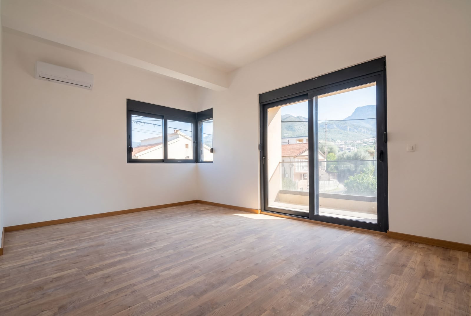 Empty bedroom with panoramic window, air conditioning, and mountain view in Bar, Montenegro