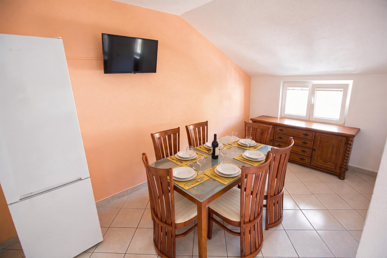 Dining area with a wooden table and chairs in an attic apartment in Budva, Montenegro