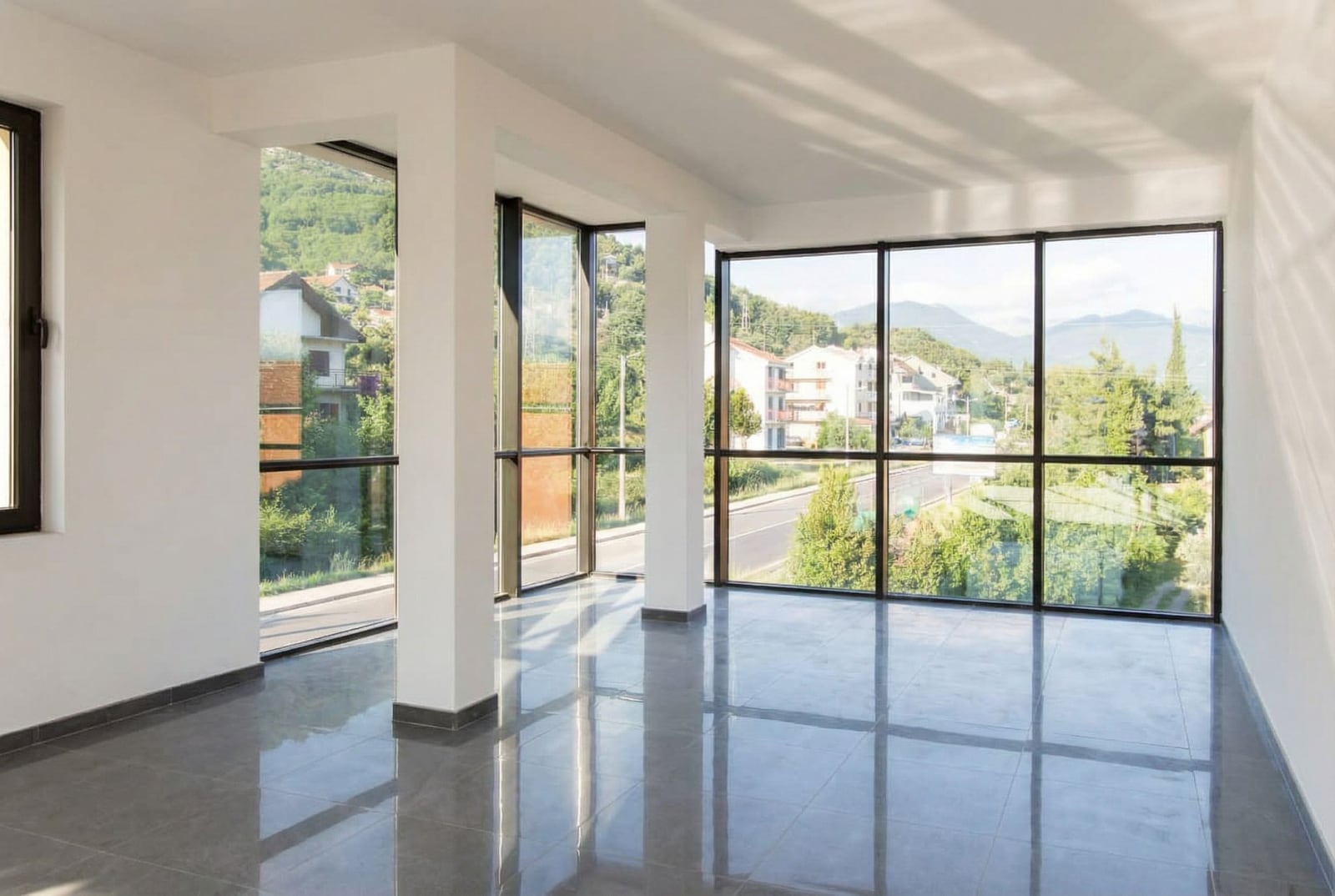 Bright living room with panoramic windows and mountain views in Baošići, Montenegro: modern interior with tiled flooring.