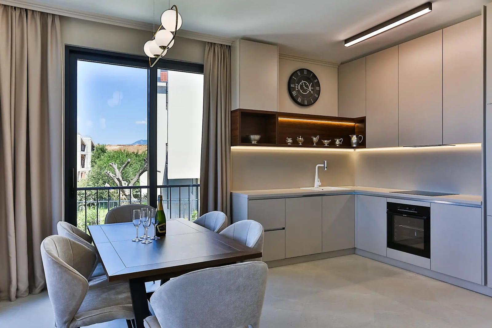 Modern kitchen-dining area in a villa in Reževići, Montenegro: light-colored cabinetry, dining area, and panoramic views.