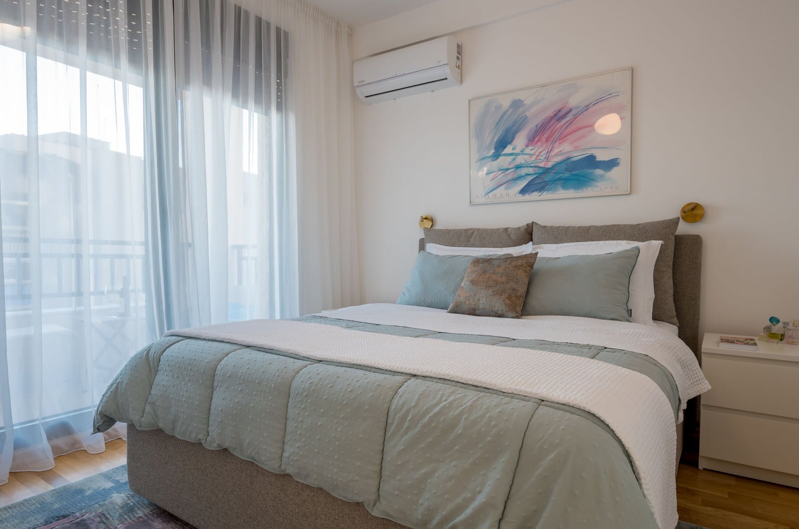 Cozy bedroom with a double bed in an apartment in Tivat, Montenegro, featuring balcony access and air conditioning.