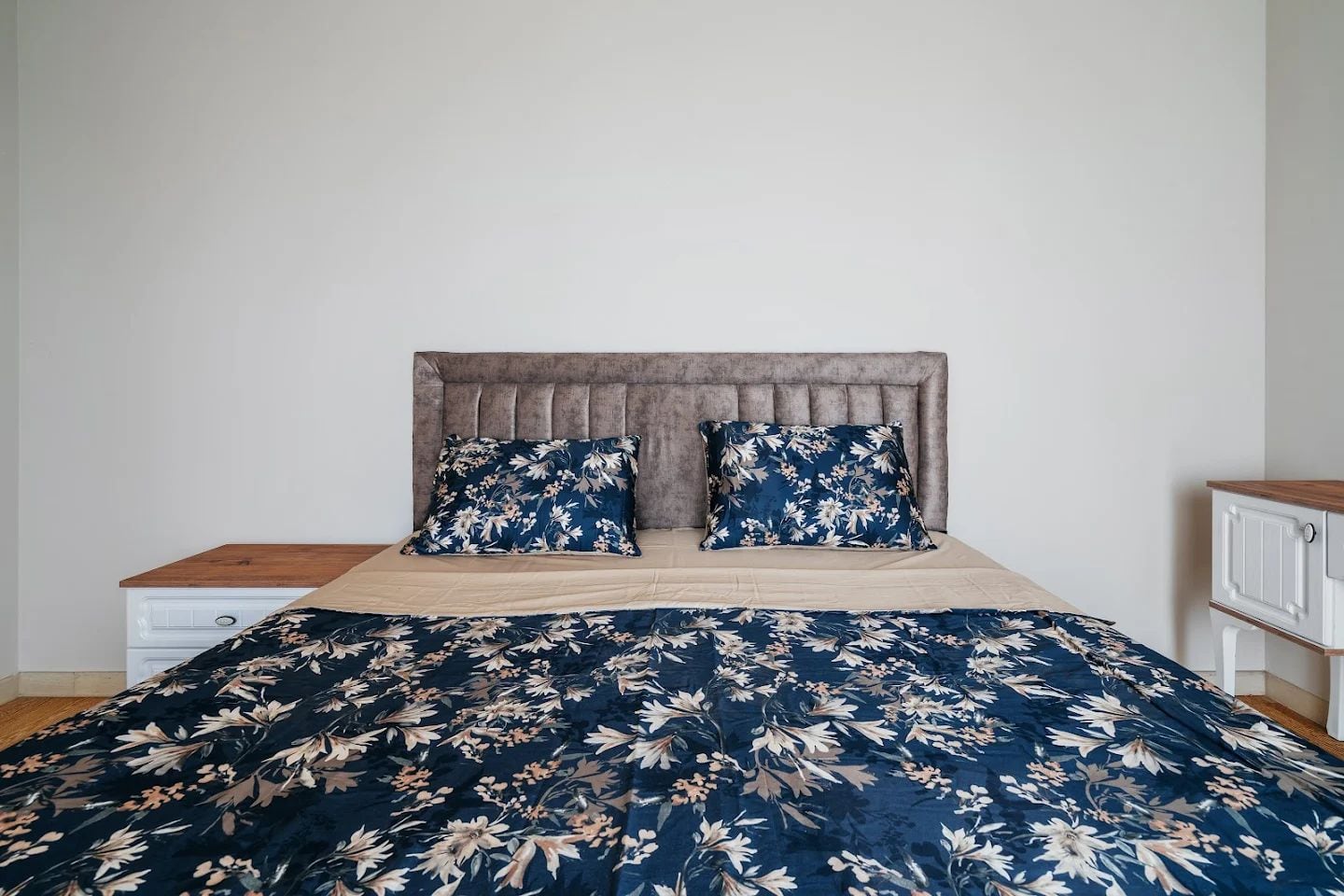 Bedroom with a double bed and upholstered headboard in an apartment in Budva, Montenegro. Modern interior with nightstands.