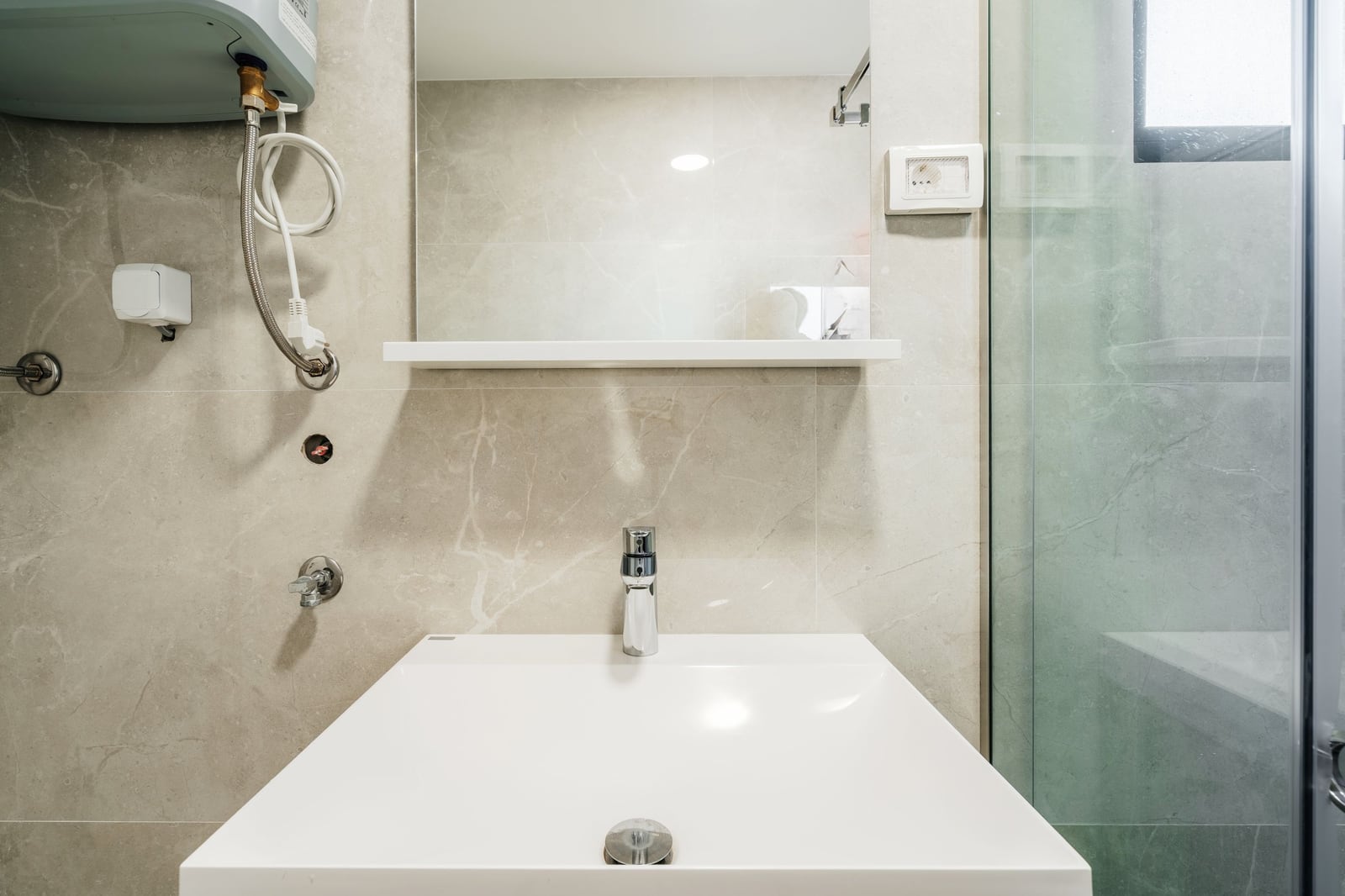 Modern bathroom with a shower cabin and light-colored tiles in a residential complex, Budva, Montenegro.