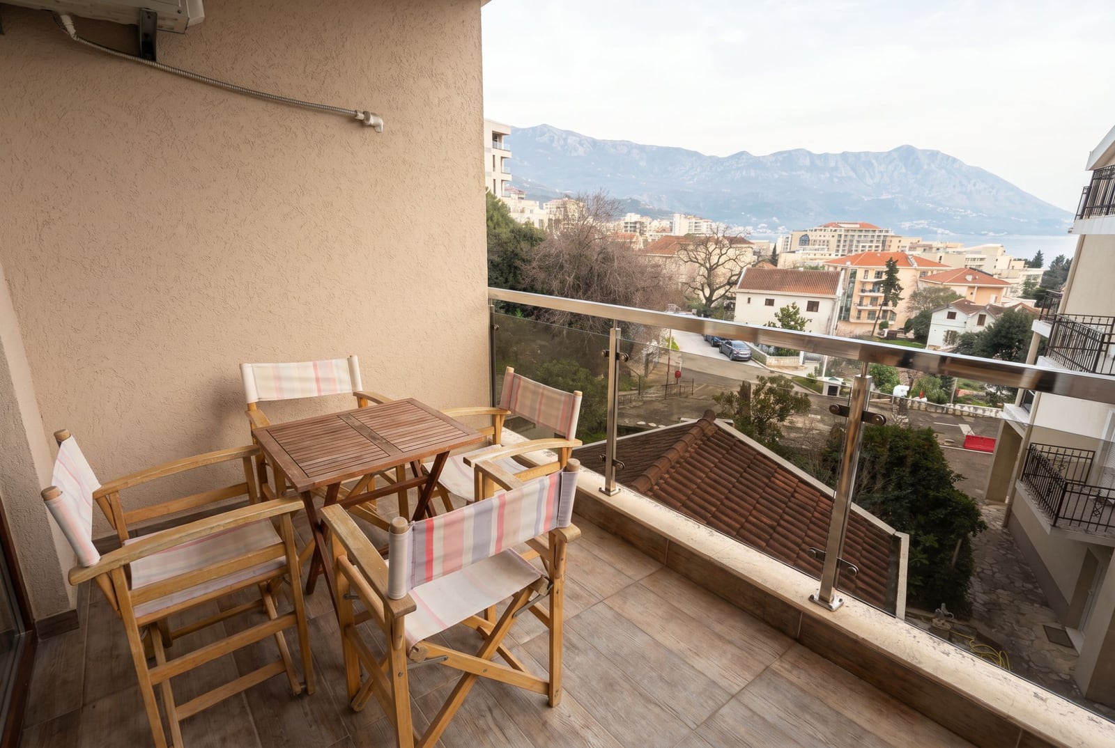 Balcony with wooden furniture and panoramic views of the mountains and sea in an apartment, Becici, Budva, Montenegro.