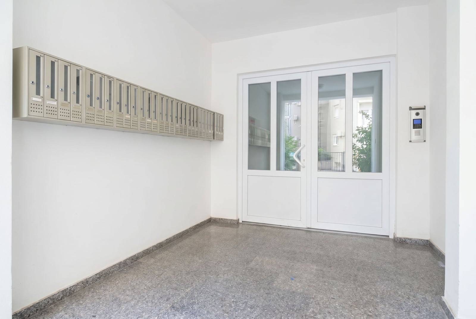 Bright entrance of a residential building with mailboxes and an intercom in Budva, Montenegro