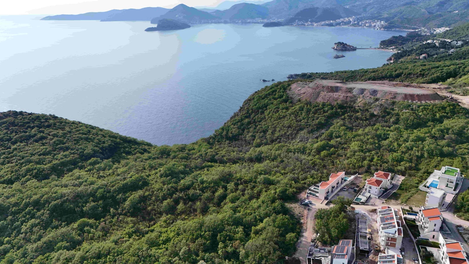 Panoramic view of the sea and villas in Markovići, Montenegro: a land plot with green landscape and sea scenery.