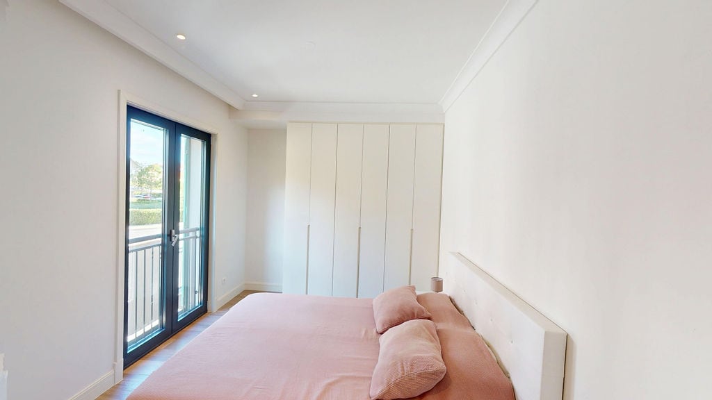 Bright bedroom with a double bed and built-in wardrobe in an apartment, Luštica, Montenegro.