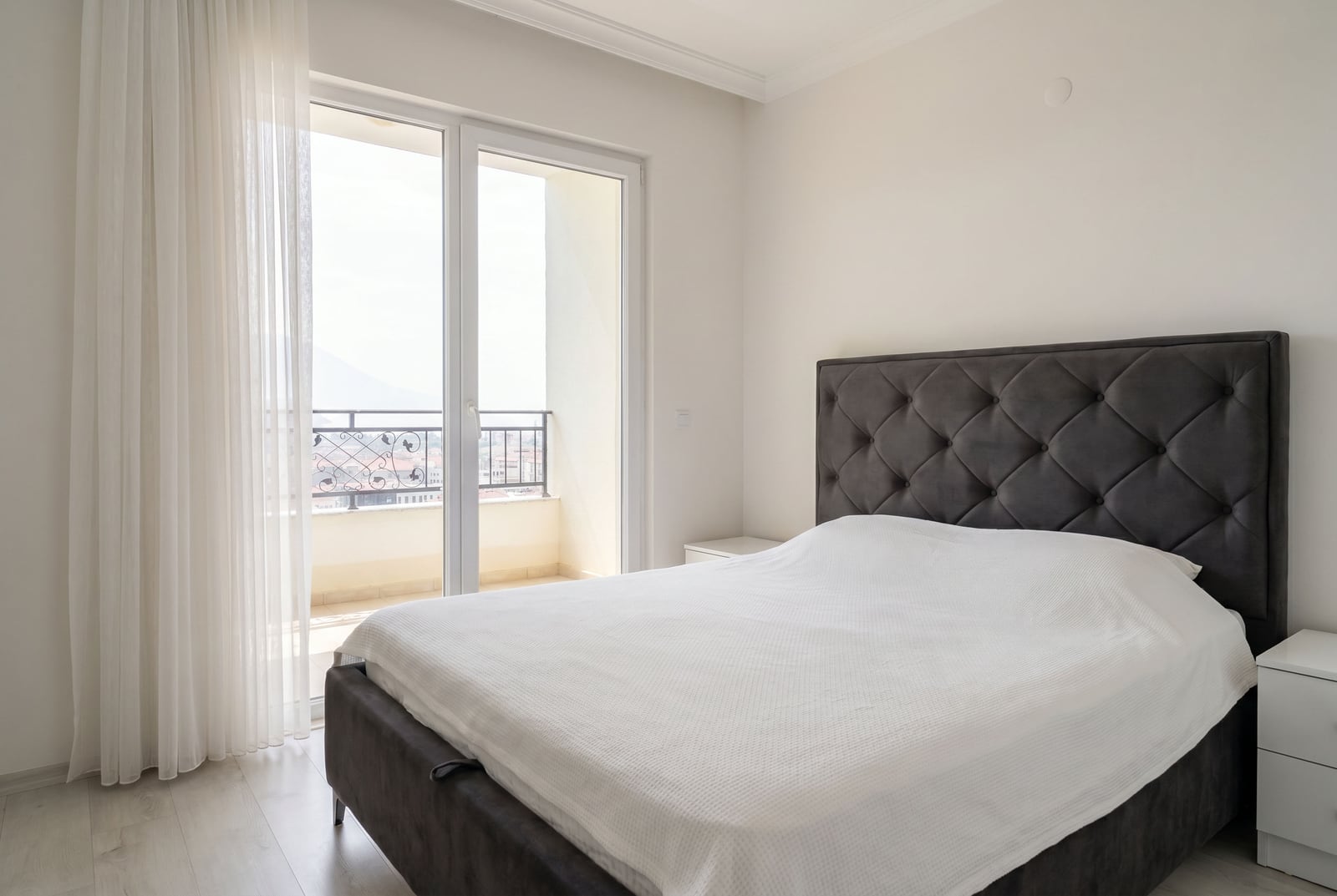 Bright bedroom with a double bed and balcony access in an apartment in Budva, Montenegro