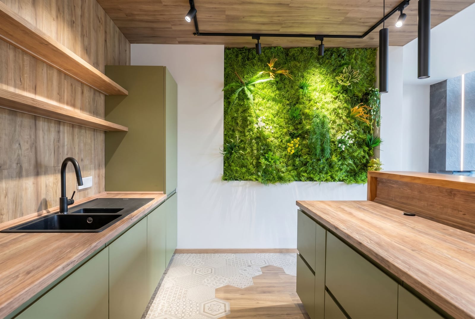 Modern kitchen with a green wall in a villa in Kavac, Montenegro: olive fronts, wooden countertops, and stylish decor.