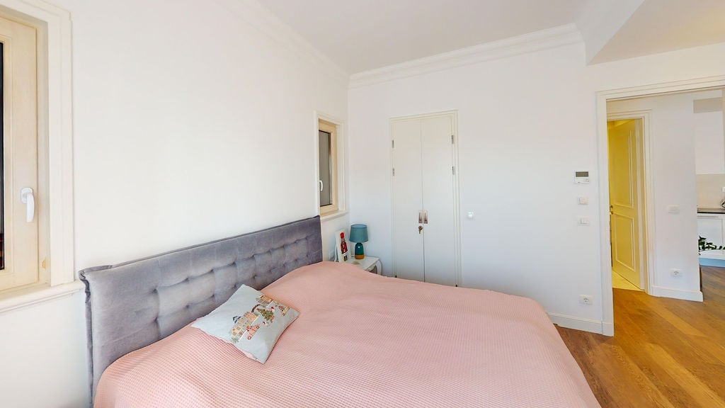 Bright bedroom with a double bed in an apartment, Luštica, Montenegro: modern interior and parquet flooring.