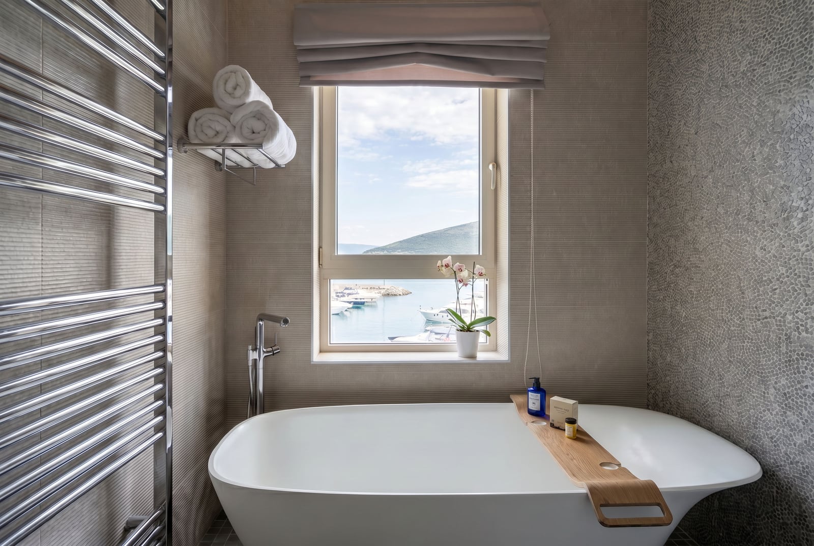 Modern bathroom with a view of the marina in Luštica, Montenegro: freestanding bathtub and stylish finishes.