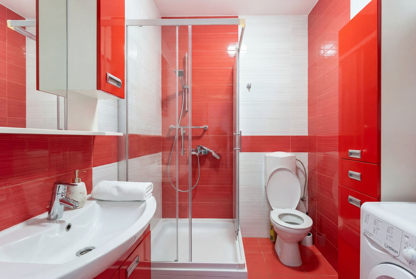 Modern bathroom with a shower cabin in an apartment in Pržno, Montenegro: bright design, red tiles, and furniture.