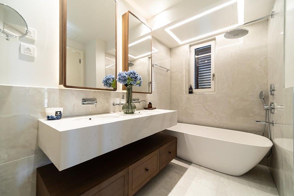 Modern bathroom with a freestanding bathtub and wooden vanity in a luxury apartment, Luštica, Montenegro.