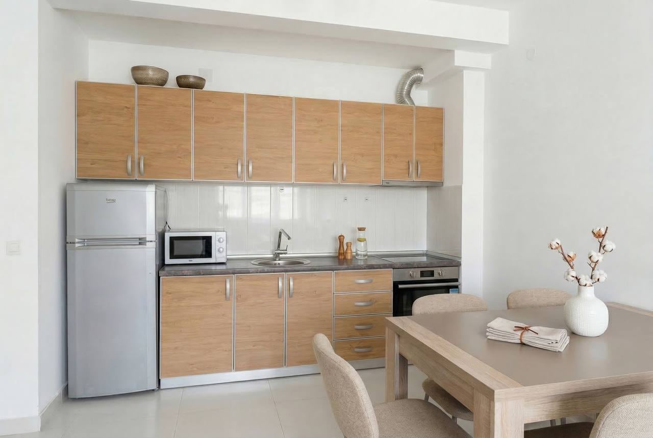 Modern kitchen with wooden cabinets and a dining area in an apartment, Bečići, Montenegro.