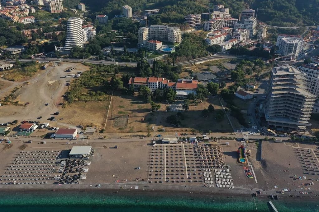 Aerial view of the beach and resort area in Bečići, Montenegro: hotels, residential complexes, and the coastline.