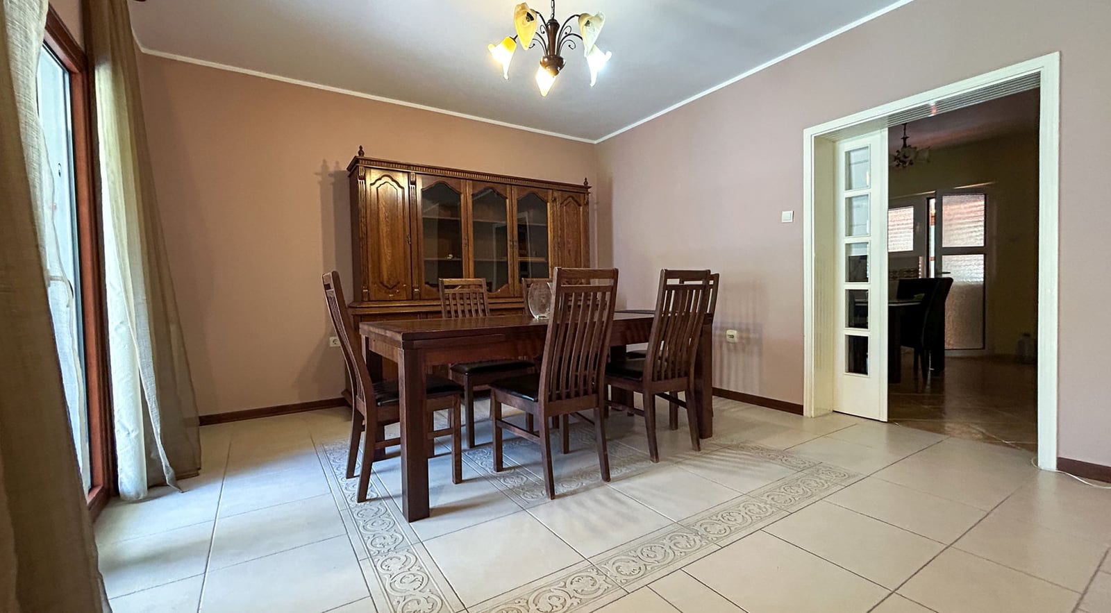 Spacious living room with a wooden dining set in a villa in Dobrota, Montenegro: tiled floor and classic style.