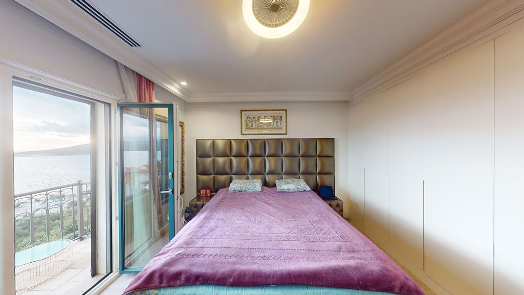 Bedroom with sea view in a townhouse, Luštica, Montenegro: double bed, built-in wardrobe, and terrace access.