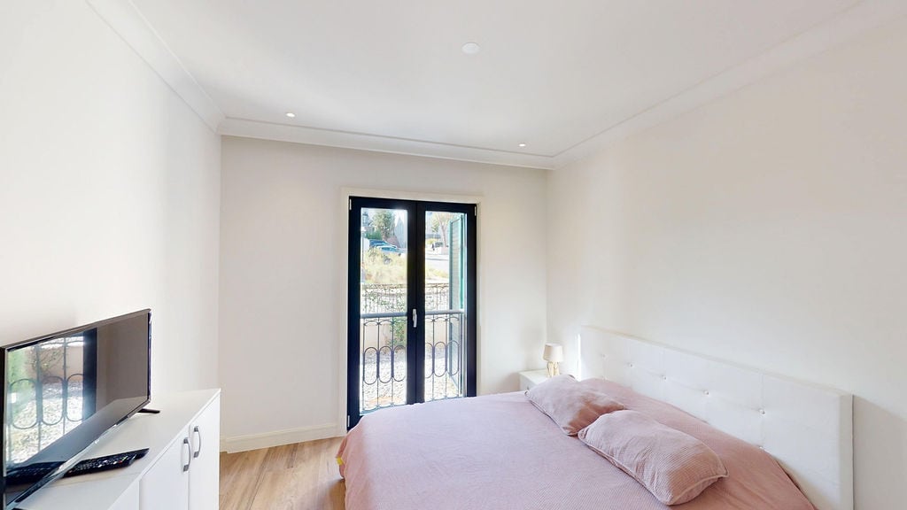 Bright bedroom with a double bed and balcony access in the Lustica Bay apartments, Montenegro.