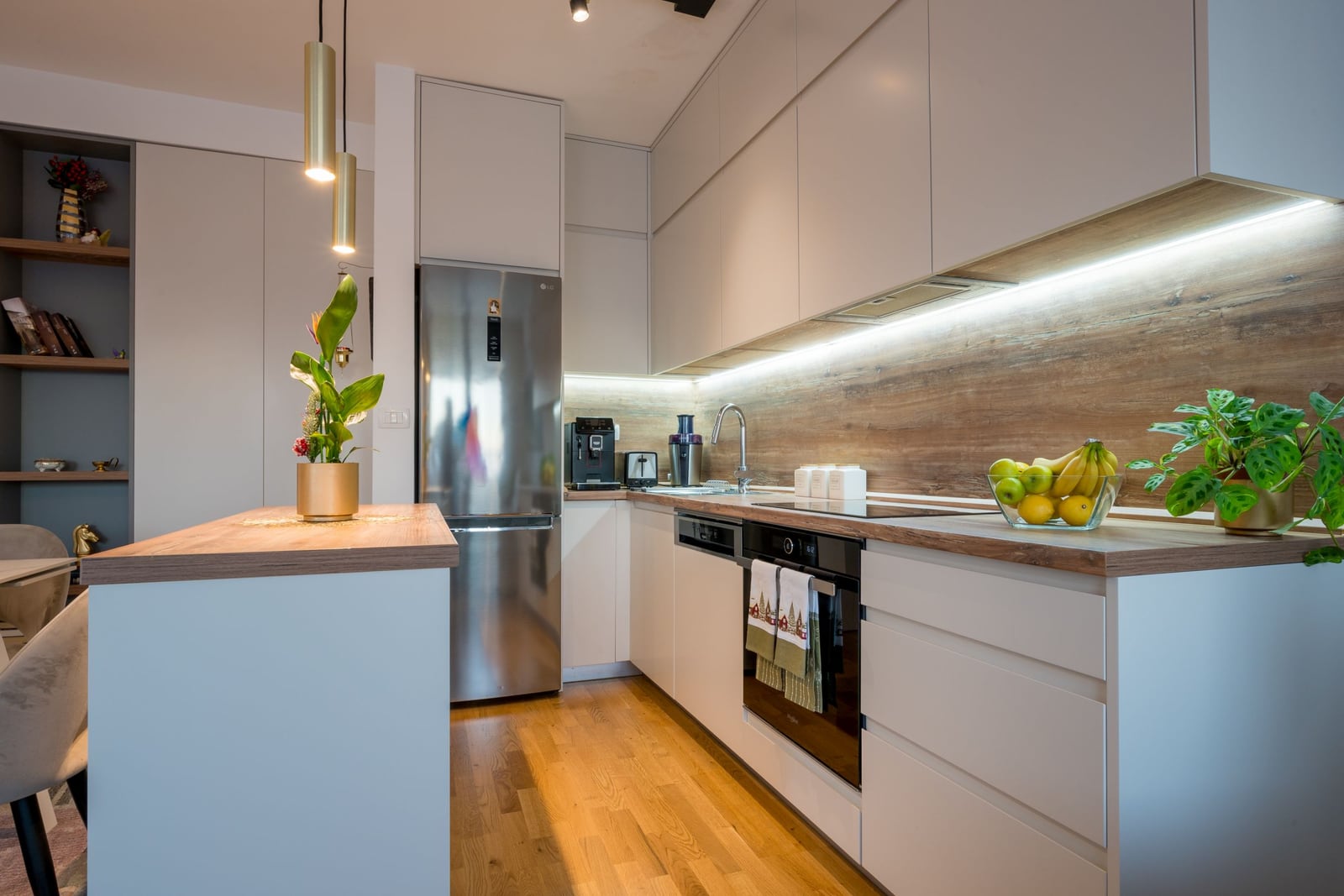 Modern kitchen in a Tivat apartment, Montenegro: light-colored cabinets, wooden countertop, and built-in appliances.