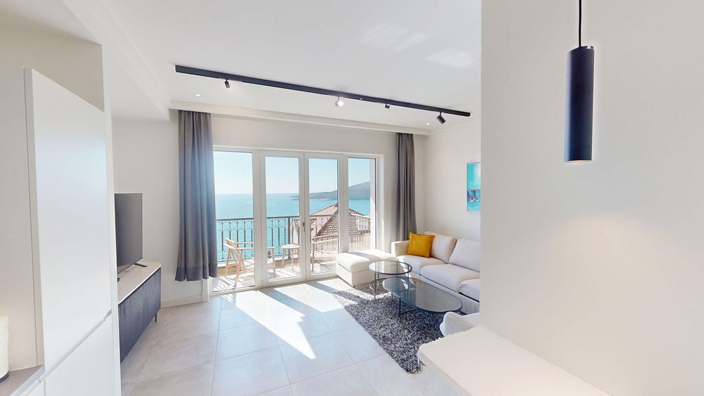 Modern living room with panoramic sea views in the Luštica development, Montenegro: bright interior, terrace, and stylish furniture.