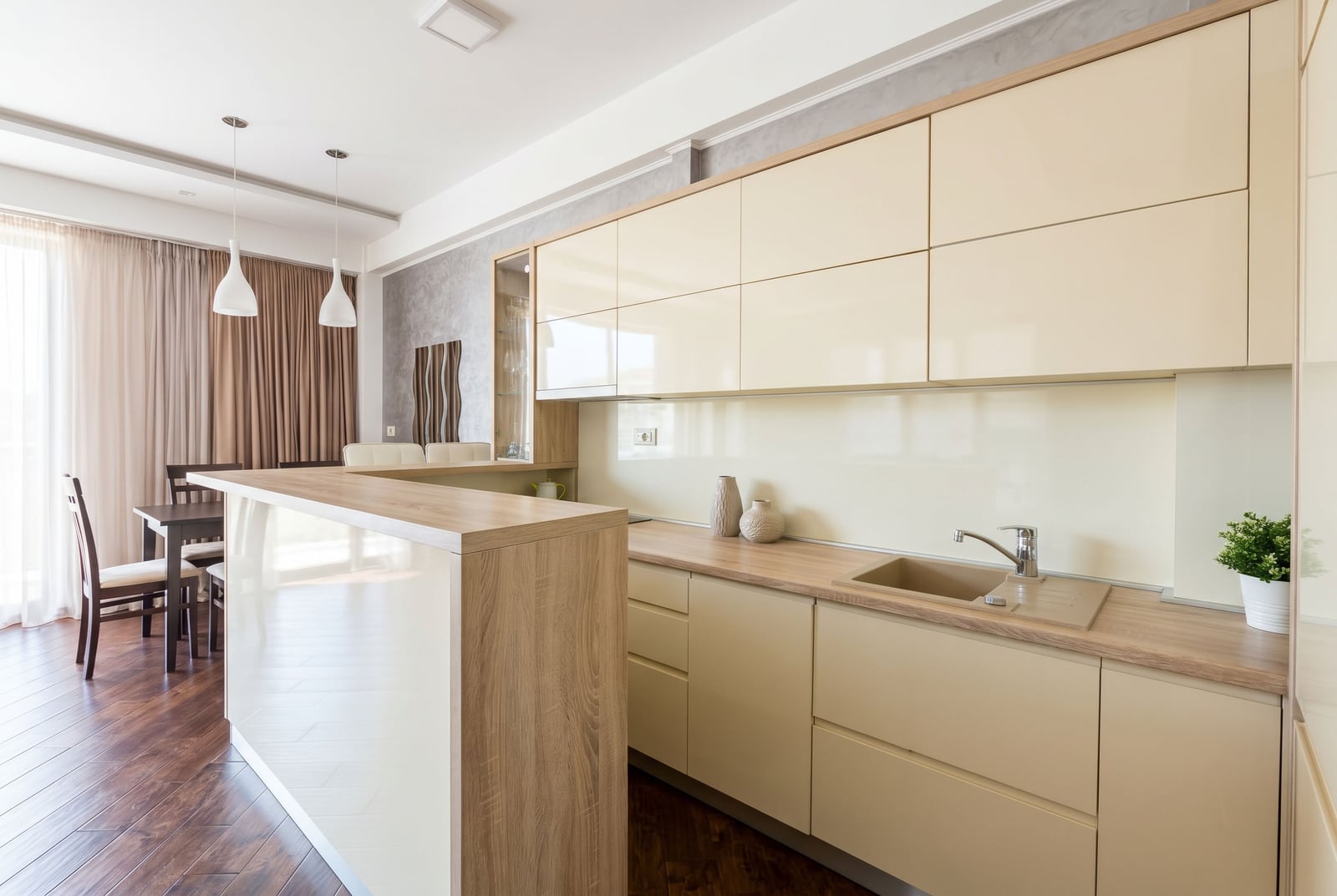 Modern kitchen with a breakfast bar and light-colored cabinetry in a Budva, Montenegro apartment. Interior featuring a dining area.
