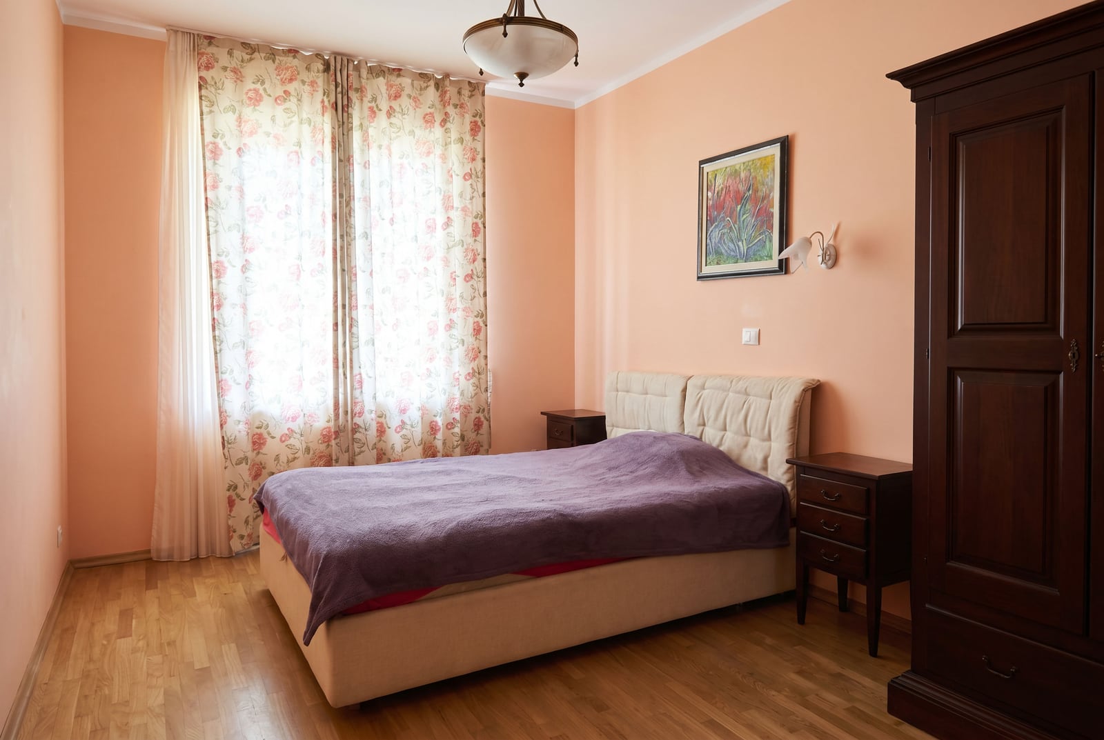 Cozy bedroom with a double bed and a dark wardrobe in an apartment for sale in Bar, Montenegro.