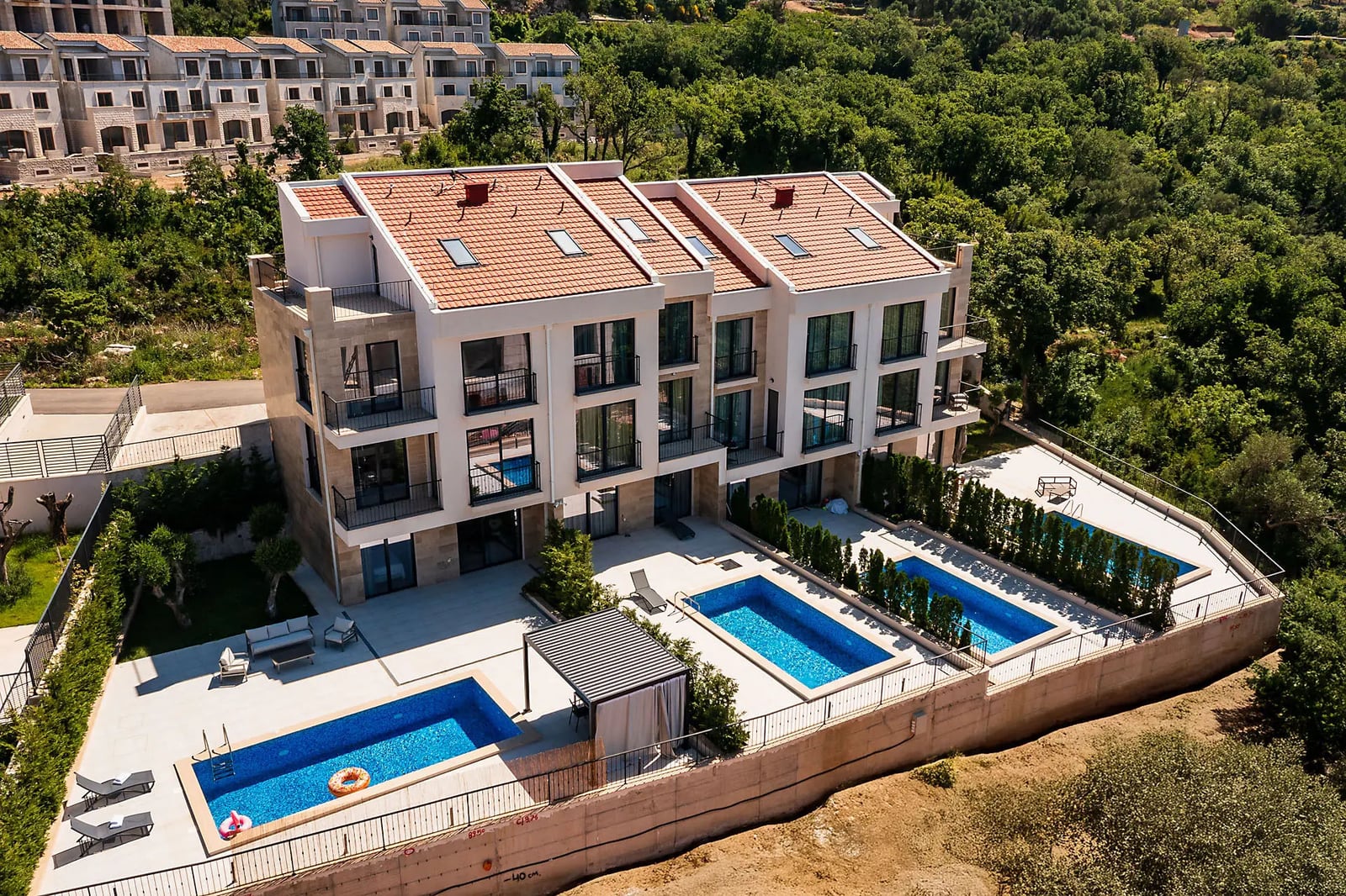 Modern villa in Reževići, Montenegro: aerial view of a three-story complex with private pools and terraces.