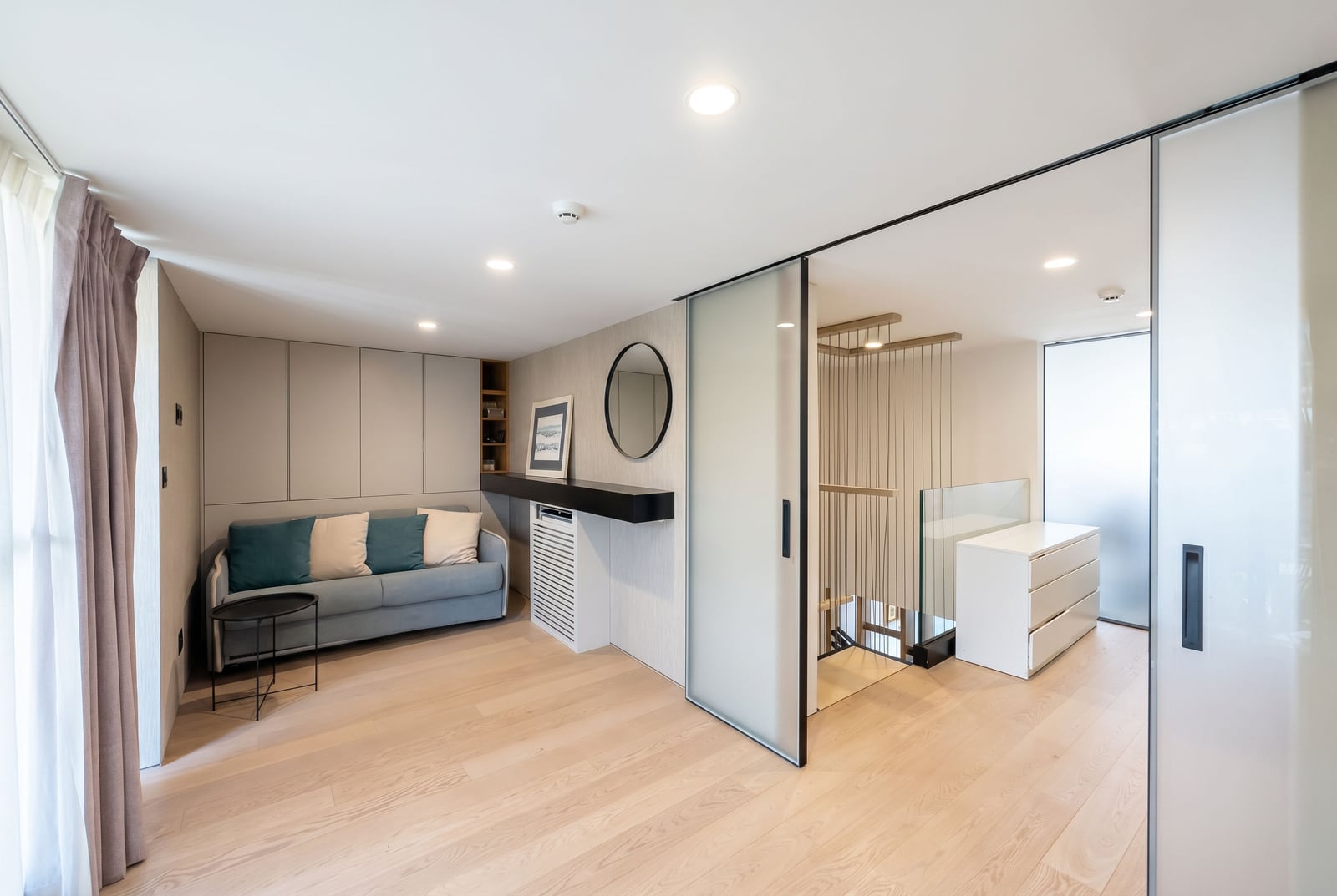 Modern living room with a sofa and glass partitions in an apartment in Budva, Montenegro. Bright interior.