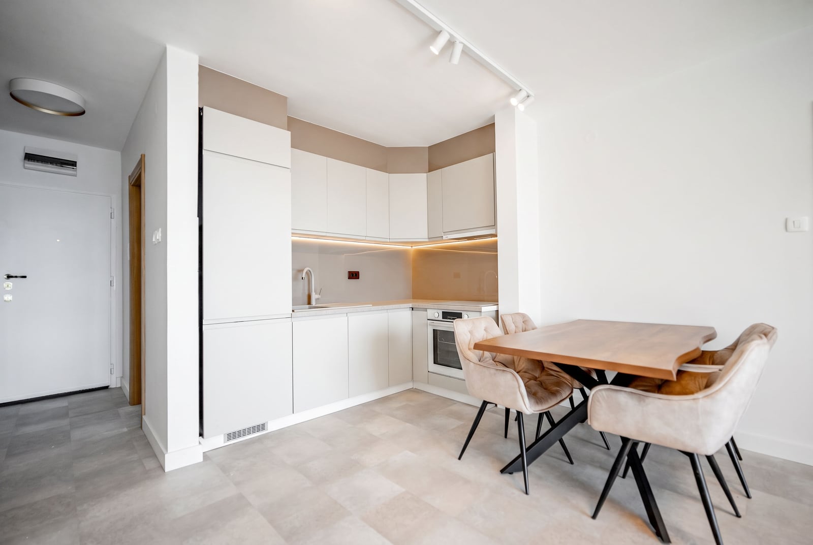 Modern kitchen in an apartment in Sveti Stefan, Montenegro: light-colored cabinetry, dining table, and upholstered chairs.