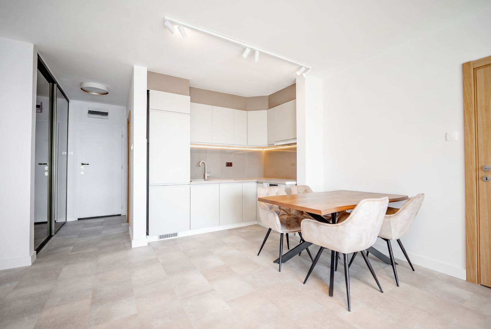 Modern kitchen-dining room in light tones in an apartment, Sveti Stefan, Montenegro: white furniture, dining area.