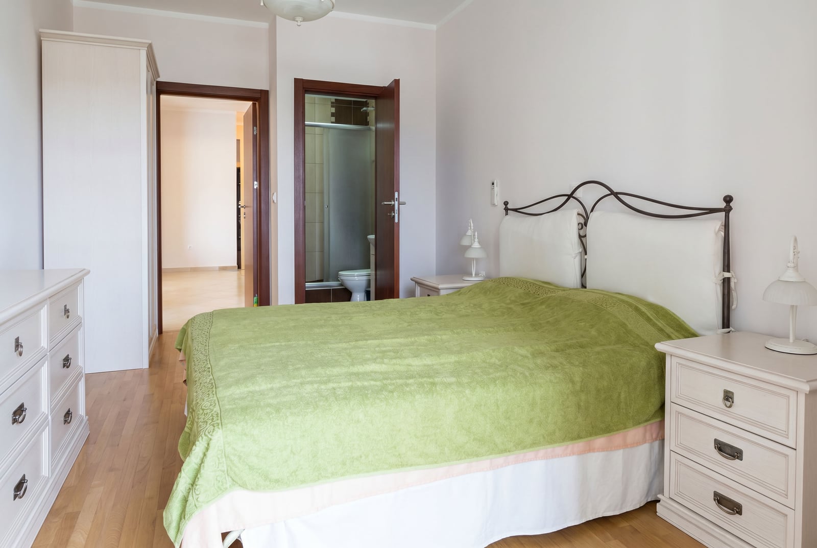 Bright bedroom with a double bed and furniture in an apartment in Bar, Montenegro, with access to a private bathroom.